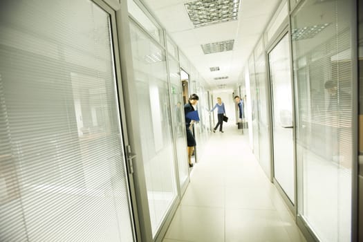 Photo of business people looking out of workshops in office building