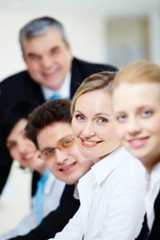 Blonde businesswoman looking at camera among her colleagues