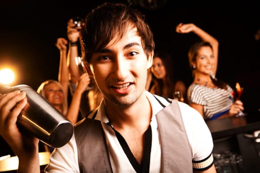 Portrait of smiling male with bottle looking at on background of dancers