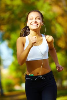 portrait of a young woman jogging and listening to the player