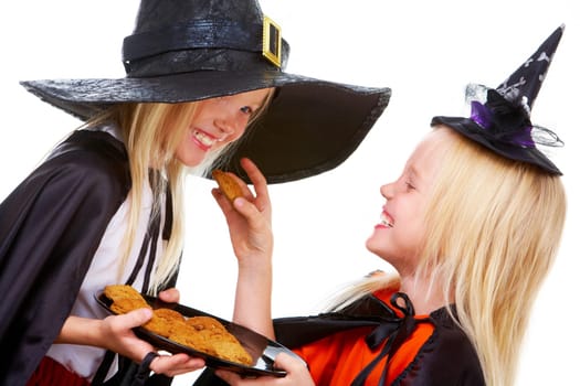 Photo of girl in Halloween costume with tray of bisquits offering one to her twin sister