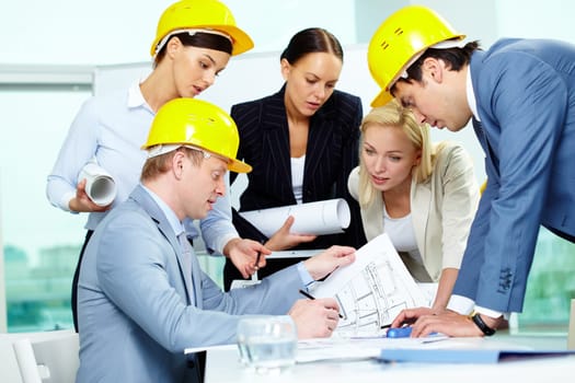 Group of architects discussing draft of new construction