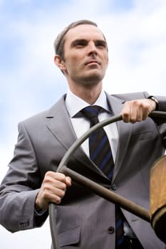 Portrait of powerful businessman holding steer and looking forwards on white background