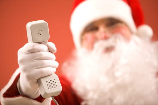 Photo of Santa Claus giving phone receiver to you