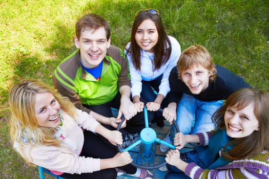 Circle of happy friends looking at camera with smiles at leisure
