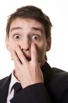 Image of shocked businessman hiding his mouth under hand and looking at camera with widened eyes