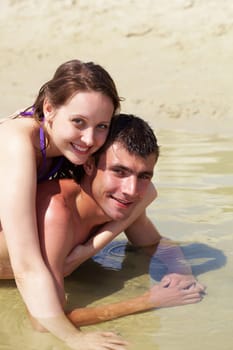 Portrait of happy couple in pure water looking at camera