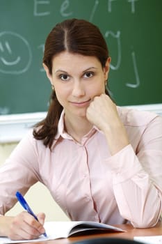 Portrait of smart teacher at workplace looking at camera