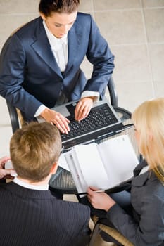 Businesspeople gathered around the table discussing a important questions
