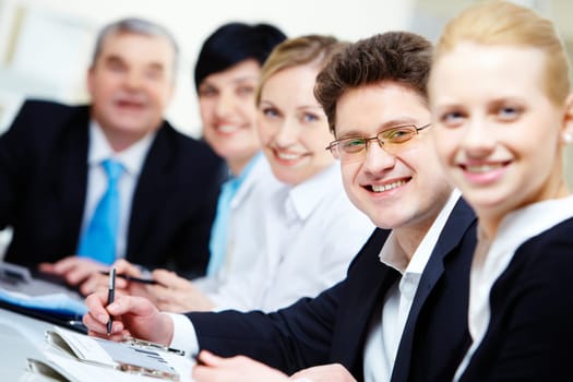 Confident businessman looking at camera among colleagues