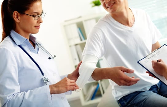 Portrait of confident female doctor giving first aid to patient in hospital