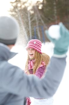 Image of attractive young woman flinging the snowball and having fun