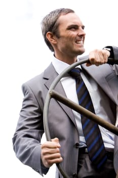Portrait of powerful businessman steering while looking aside on background of sky
