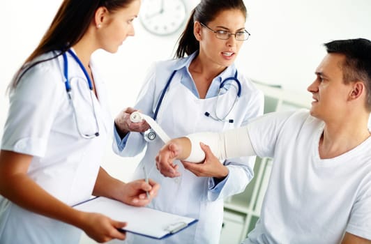 Portrait of confident female doctor giving first aid to patient in hospital