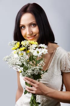 Portrait of pretty girl with bunch of chrysanthemums looking at camera