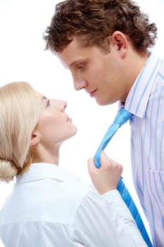 Portrait of female holding mans tie while looking at him