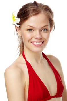 Portrait of a young smiling girl in bikini and with a flower