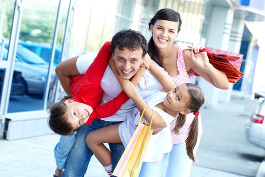 Portrait of happy family of four with shopping bags