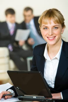 Portrait of beautiful employee on the background of her coworkers