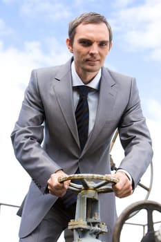 Photo of powerful businessman steering on background of blue sky