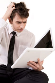 Portrait of puzzled businessman looking into open laptop