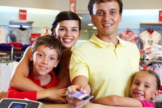 Portrait of family of four giving credit card
