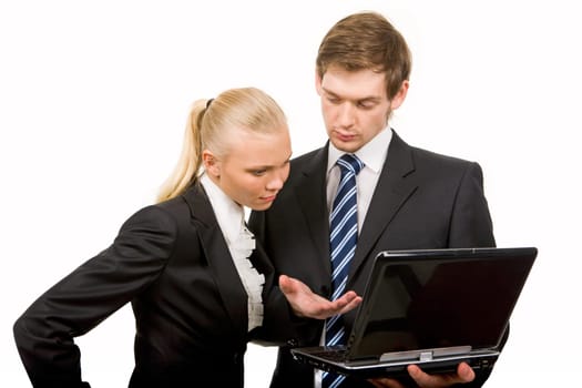 Portrait of co-workers looking at laptop screen while discussing new ideas