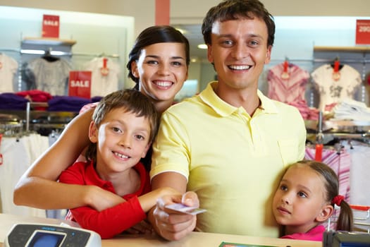 Portrait of family of four giving credit card
