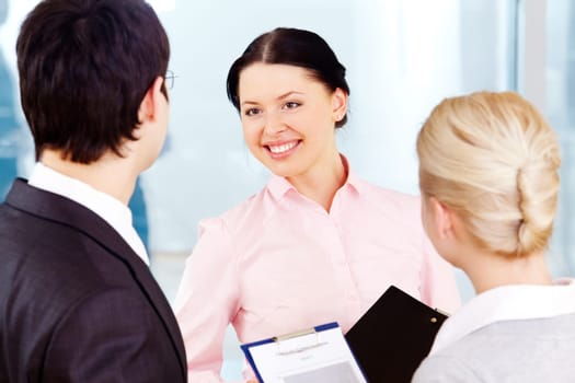 Photo of smart women looking at her colleagues with smile during dialogue