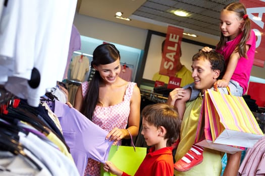 Portrait of a family with shopping bags choosing new clothes in the mall