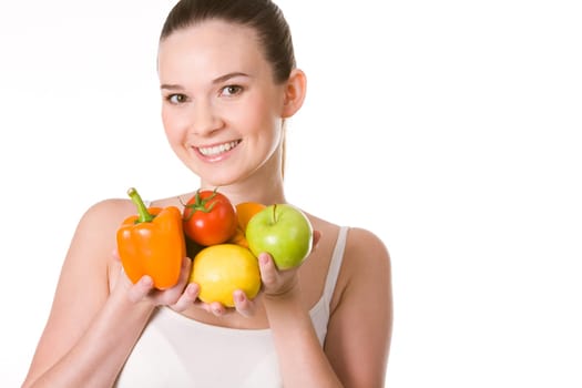 Portrait of pretty girl holding different fruits and vegetables in hands and smiling