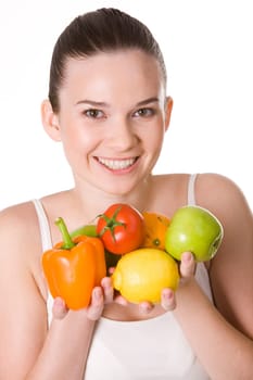 Portrait of pretty girl holding different fruits and vegetables in hands