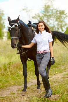Image of happy female with purebred horse outdoors
