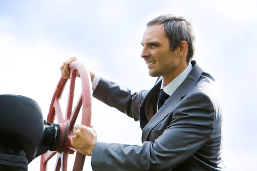 Portrait of confident captain holding rudder while steering