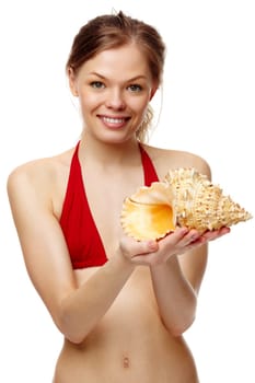 Portrait of a young girl in bikini with seashell looking at camera