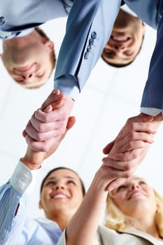 Two pairs of successful associates handshaking after striking deal with partners