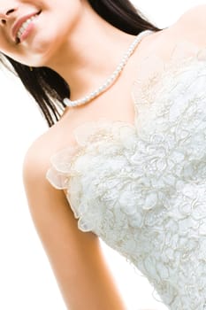 Close-up of beautiful bride in white dress and beads on her neck