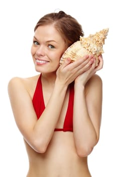 Portrait of a young girl in bikini holding a seashell