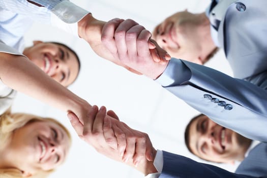 Below view of four people handshaking