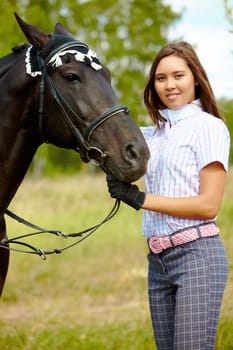 Portrait of smiling female with purebred horse outdoors