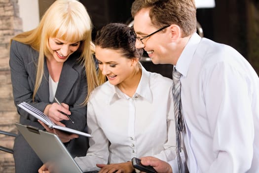 Business team of three professionals discussing a strategy-business