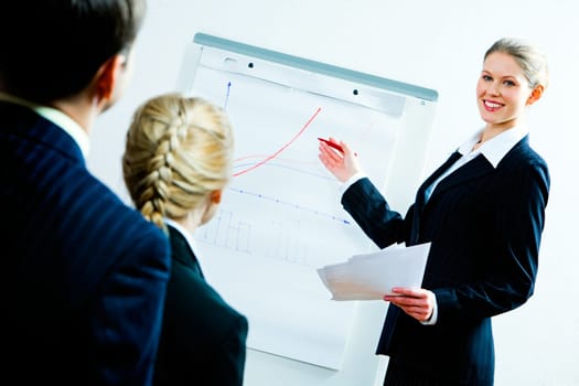 Portrait of business woman showing a plan of development to co-workers