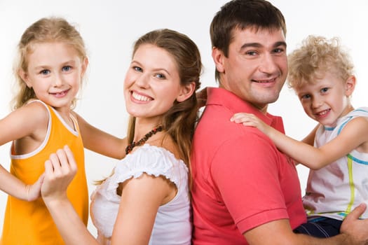 Photo of mother holding daughter and father with son on hands