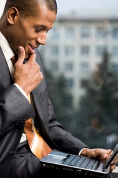 Photo of successful employee looking at laptop display during work