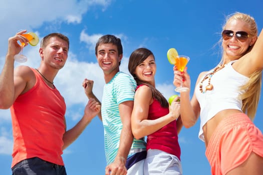Portrait of happy young friends with cocktails having beach party