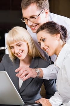 Boss is explaining the correct way of analysis to his colleagues in  the office pointing at the monitor
