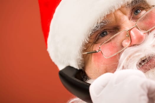 Photo of happy Santa Claus with phone receiver communicating by telephone
