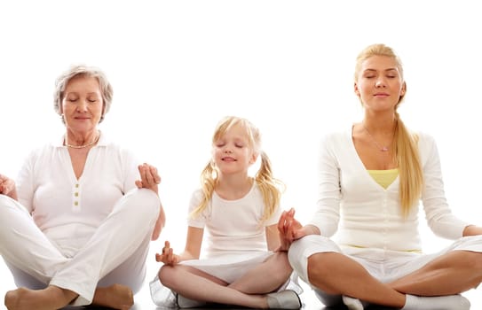Row of grandmother, mother and child meditating together