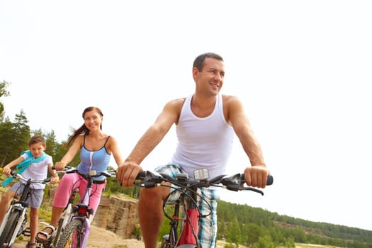 Sportive man on bike in front of his wife and son