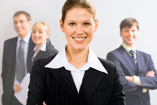 Portrait of attractive leader with her business team in the background